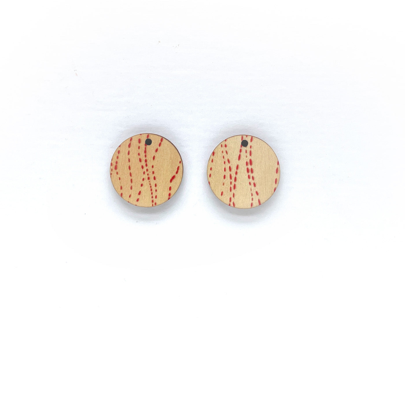 Round wooden earrings with red pattern on a white background