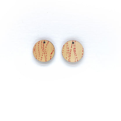 Round wooden earrings with red pattern on a white background