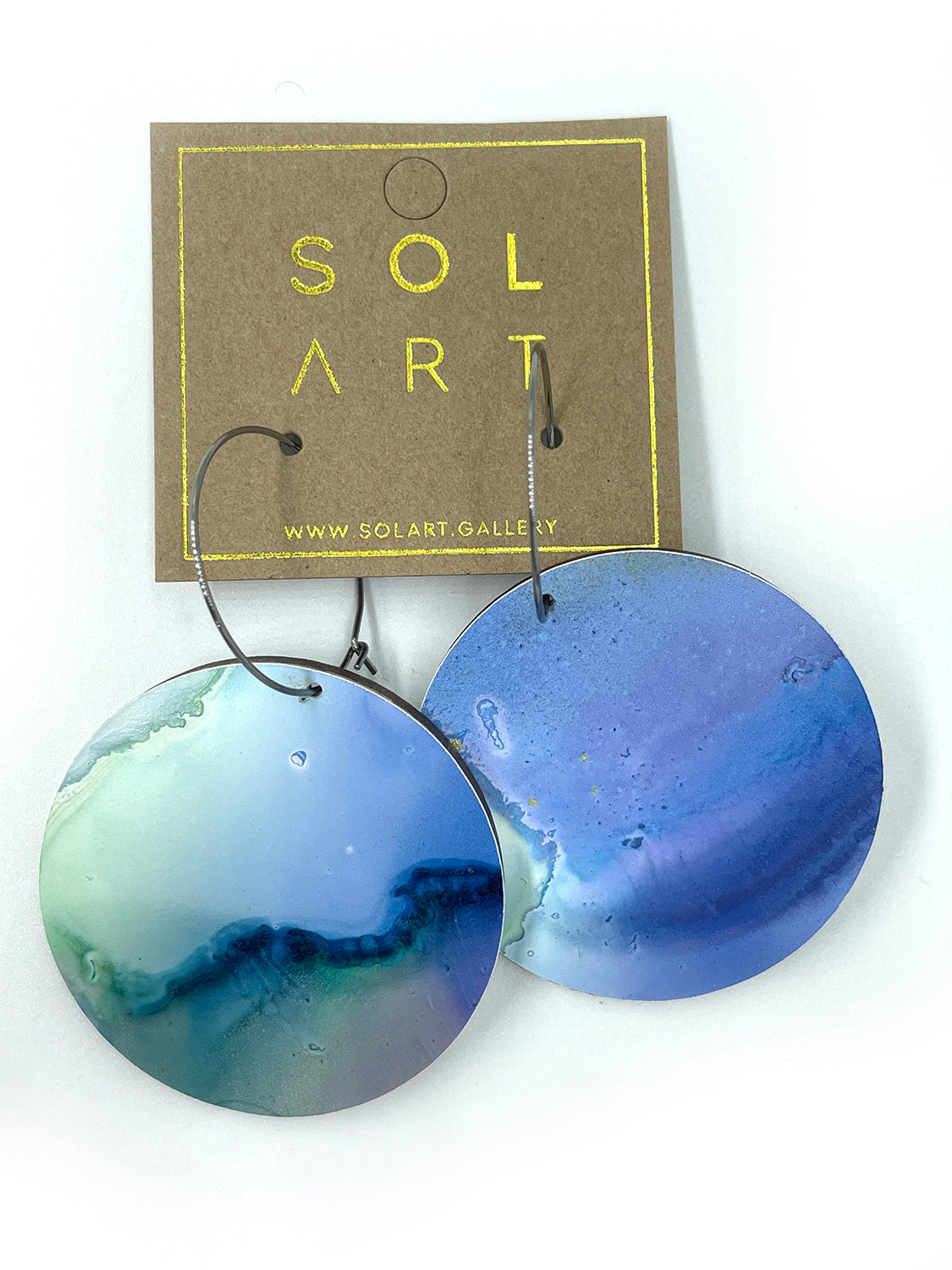 Shop women's wooden earrings named 'White Beauty Large shaped as a disc. Painted with inks on Yupo paper with stainless steel hoops. Made in Australia.