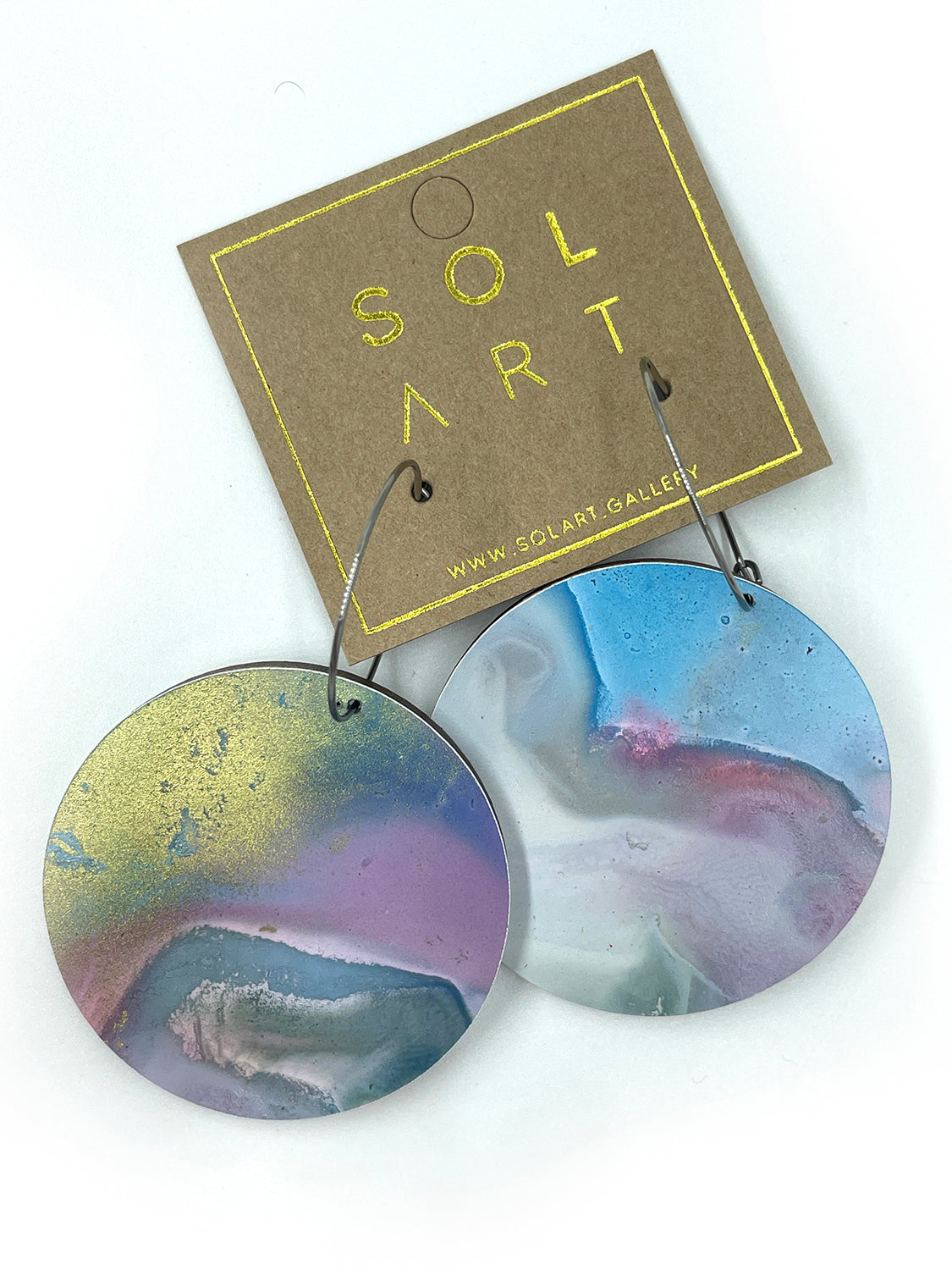Shop women's wooden earrings named 'White Beauty Large shaped as a disc. Painted with inks on Yupo paper with stainless steel hoops. Made in Australia.