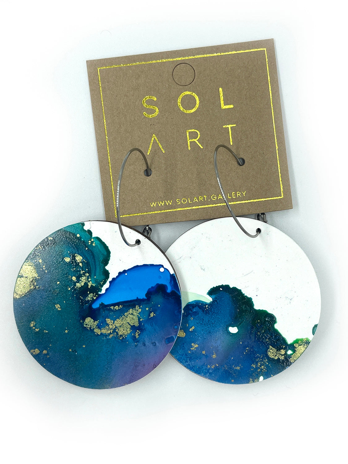 Shop women's wooden earrings named 'White Beauty Large shaped as a disc. Painted with inks on Yupo paper with stainless steel hoops. Made in Australia.