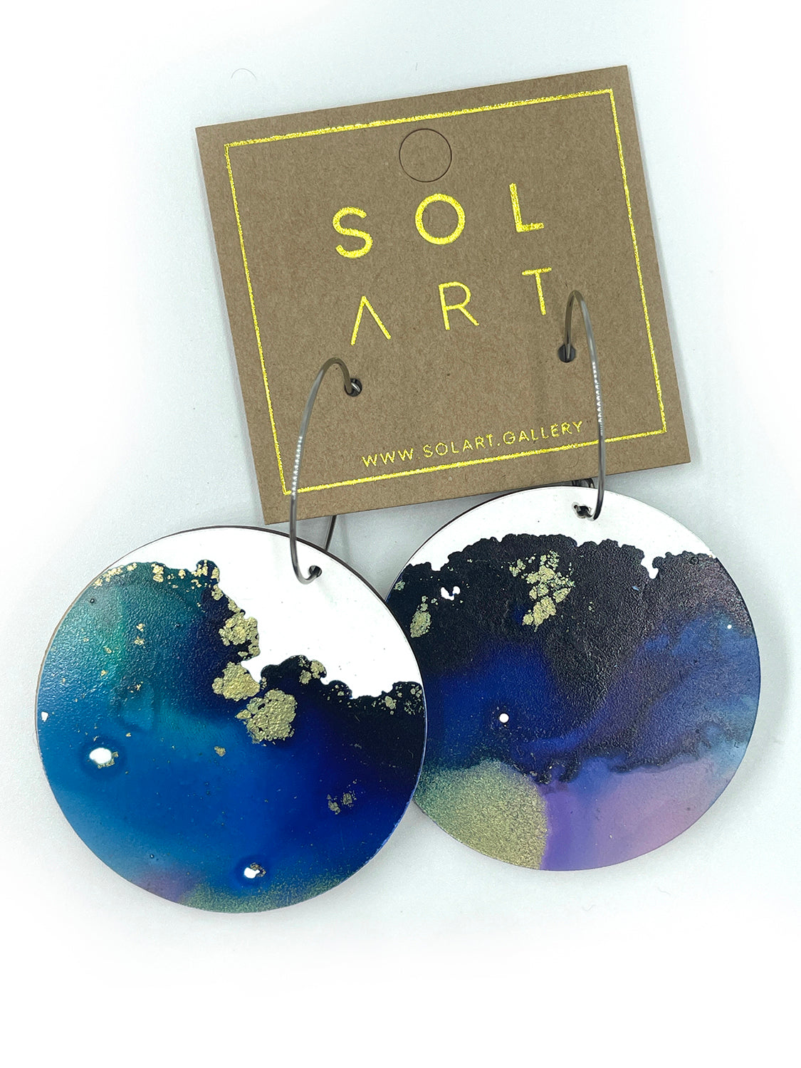 Shop women's wooden earrings named 'White Beauty Large shaped as a disc. Painted with inks on Yupo paper with stainless steel hoops. Made in Australia.