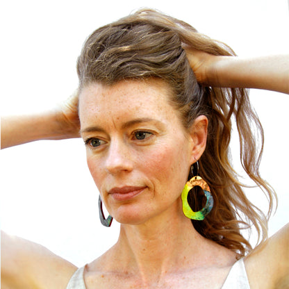 Model shot of wooden earrings named ‘Rock Hollow Ground’ shaped as a natural rock. Made from sustainable wood with stainless steel hoops. Made in Australia.