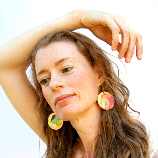 Model shot of wooden earrings named ‘Round 45 Sky’ with a round shape. Made from sustainable wood with stainless steel hoops. Made in Australia.
