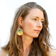 Model shot of wooden earrings named ‘Round 45 Summer’ shaped as a natural rock. Made from sustainable wood with stainless steel hoops. Made in Australia.