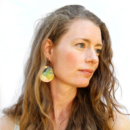 Model shot of wooden earrings named ‘Round 45 Delight’ with a round shape. Made from sustainable wood with stainless steel hoops. Made in Australia.