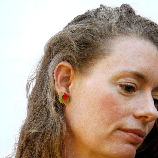 Model shot of women's wooden earrings named ‘Stud Delight’ with a round shape. Made from sustainable wood with stainless steel backs. Made in Australia.